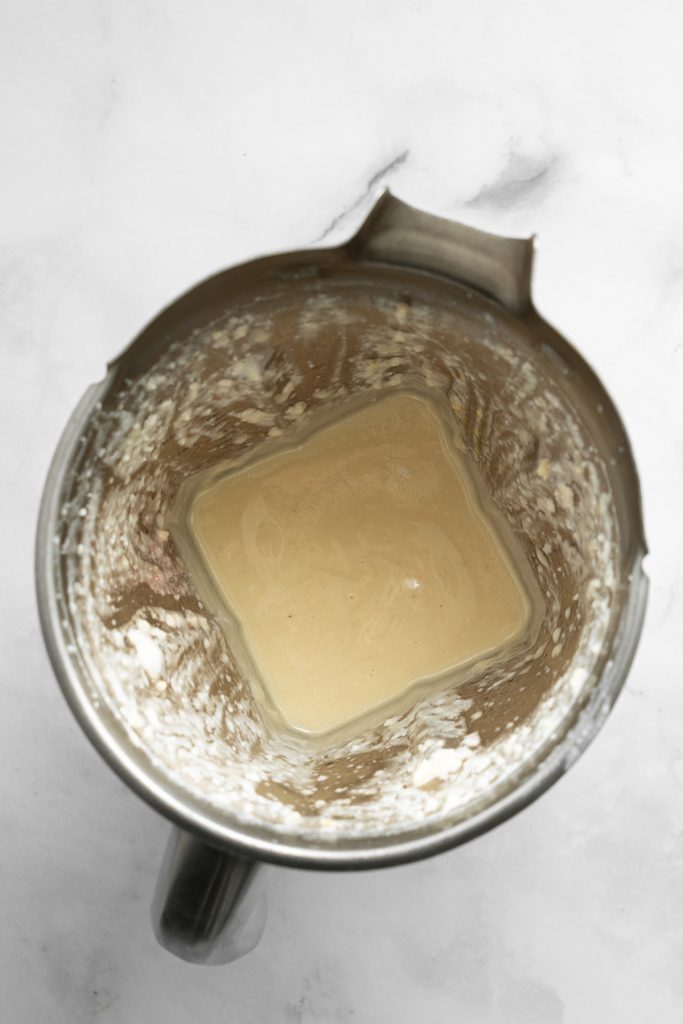 A smooth blended mixture in a stainless steel blender container.