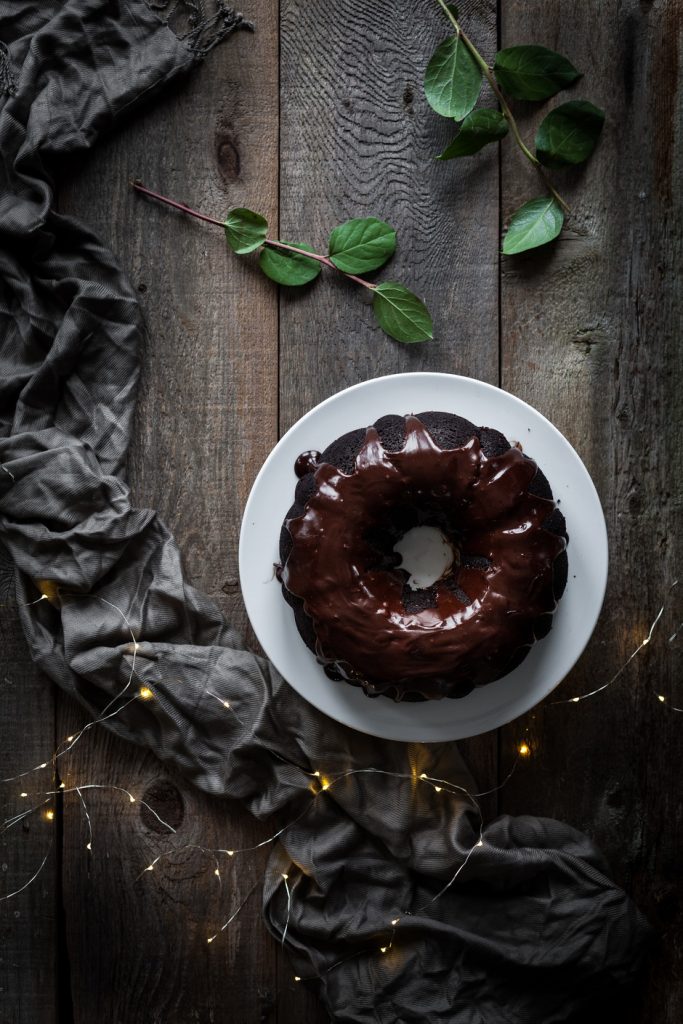 overhead image of chocolate bundt cake on a white plate.