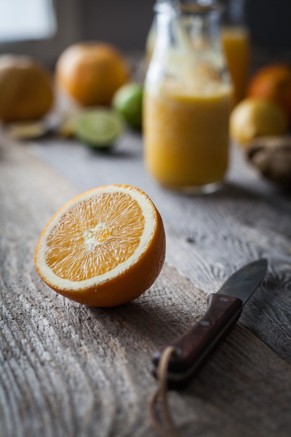 a close up portrait of an orange half sitting on a wooden table.