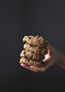 a close up of a hand holding a stack of banana bread cookies.
