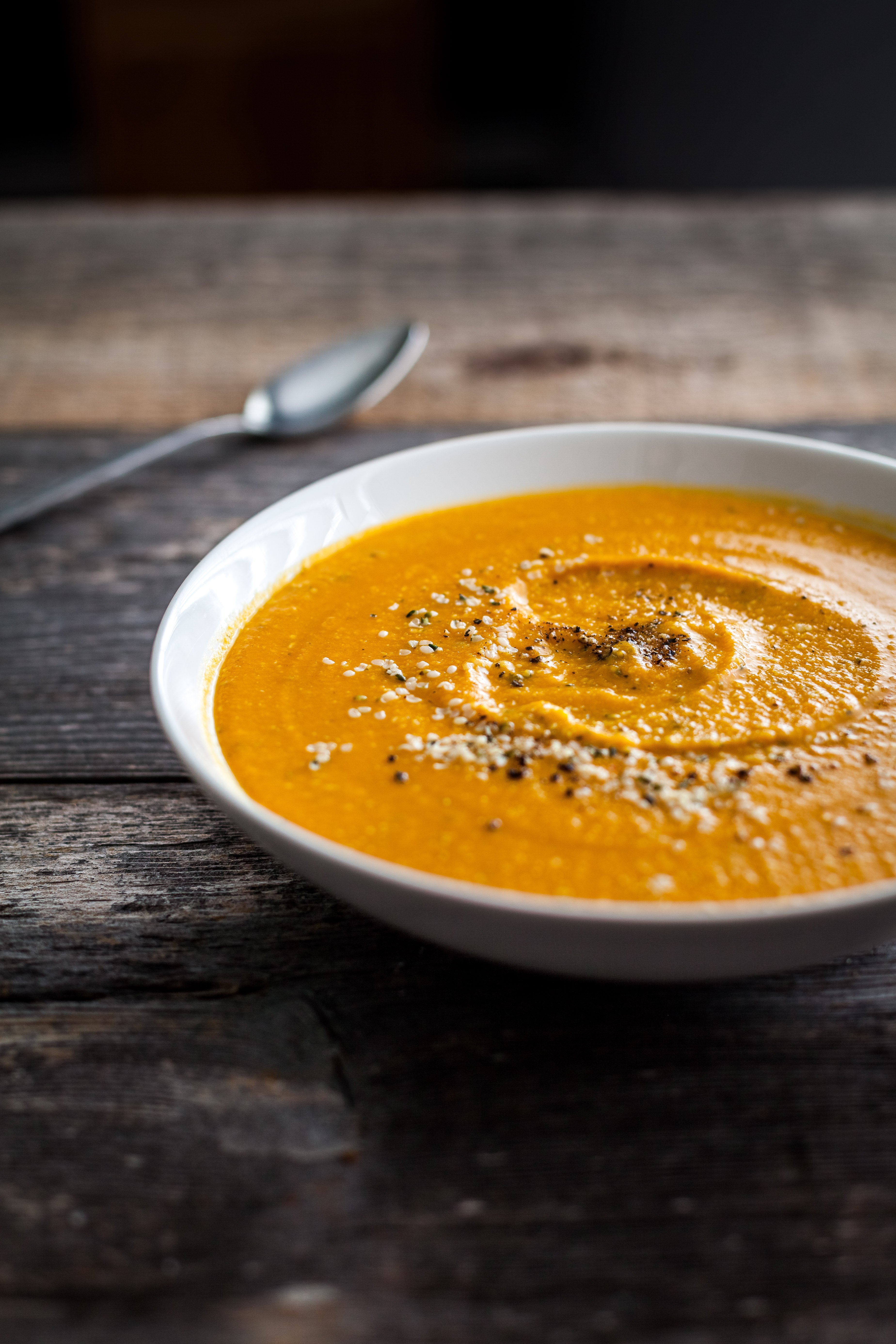 a head on image of a bowl of Sweet Potato Soup on a wood surface.