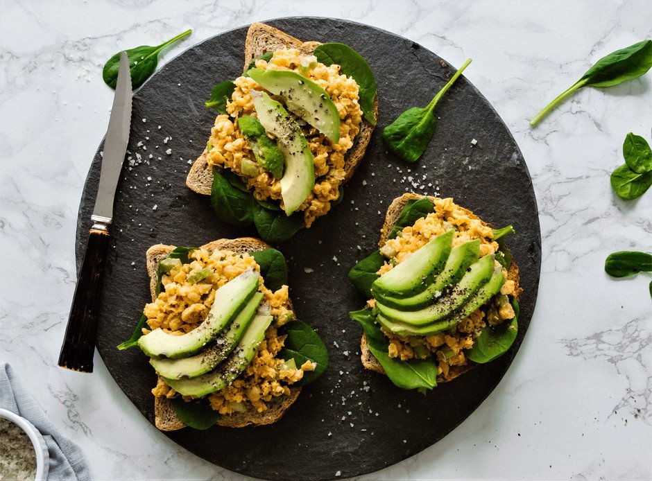 overhead image of chickpea tuna salad sandwiches with avocado and spinach.