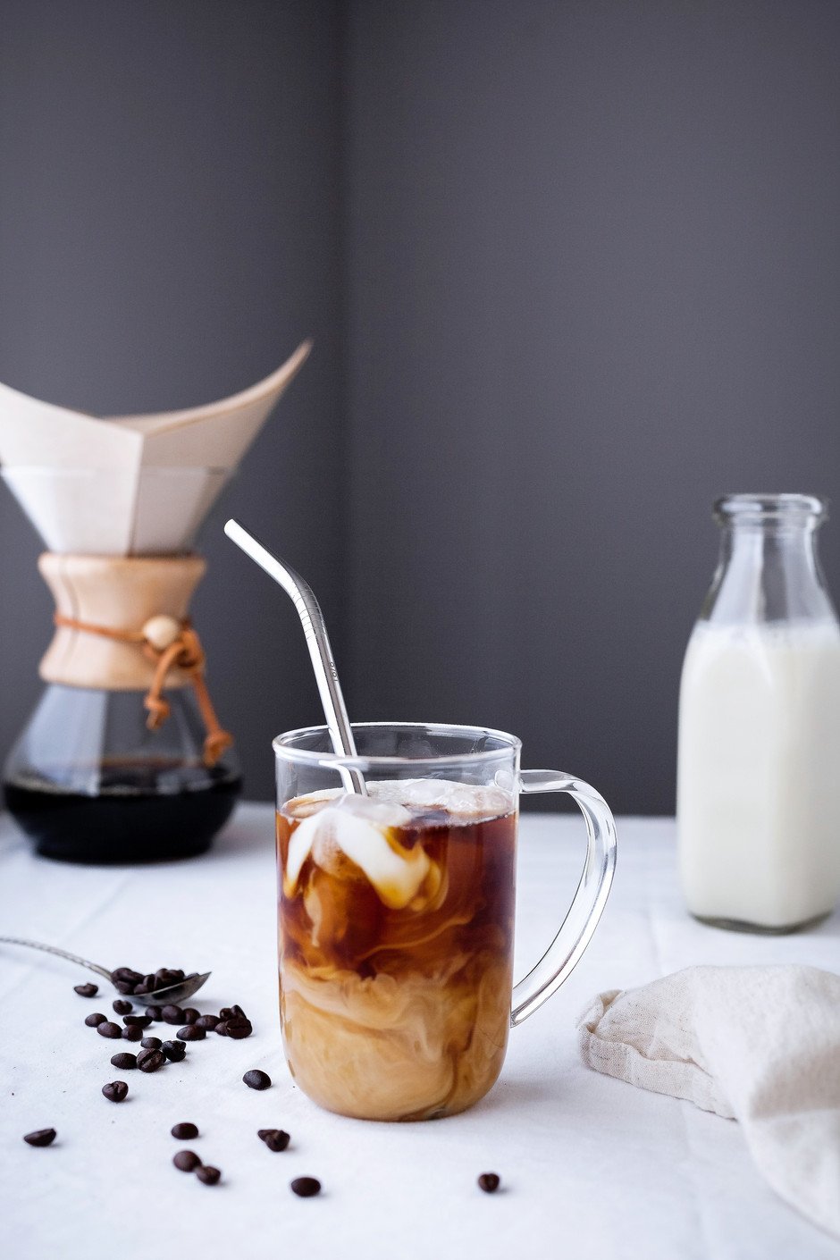 head on image of a mug with cold brew coffee and a swirl of almond milk with ice. 