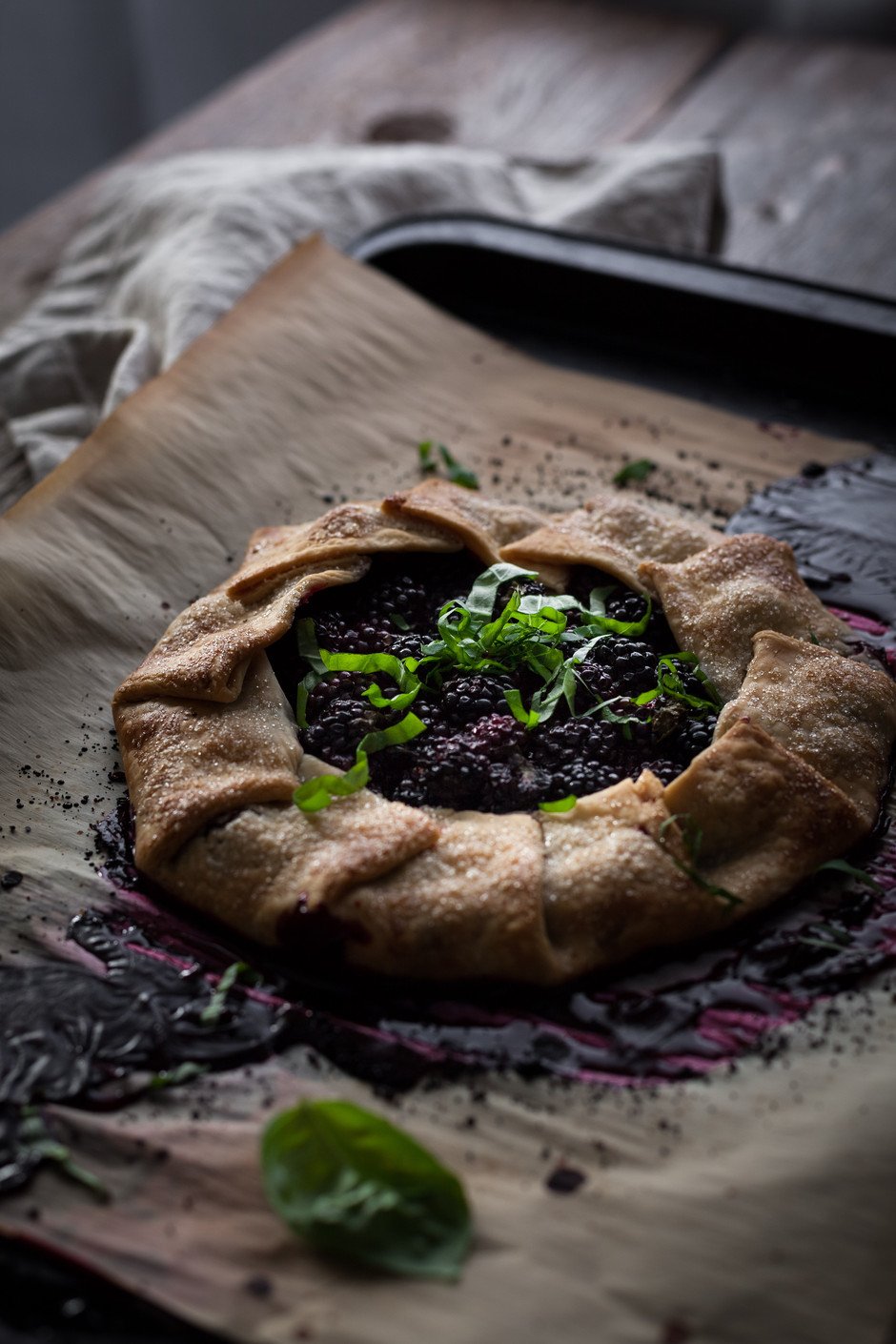 angled view of a blackberry galette on a baking tray.