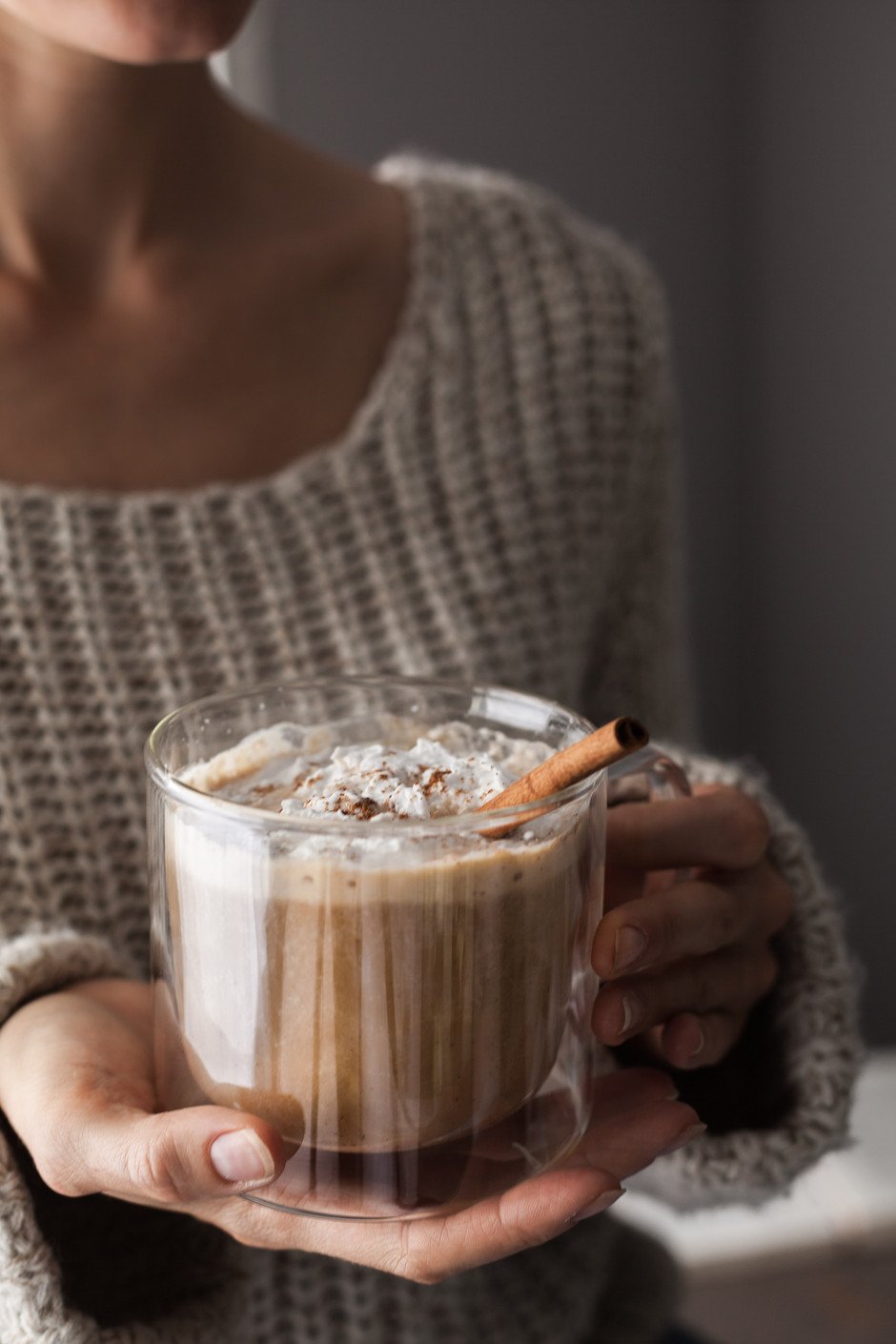 woman holding a mug of pumpkin spice latte.