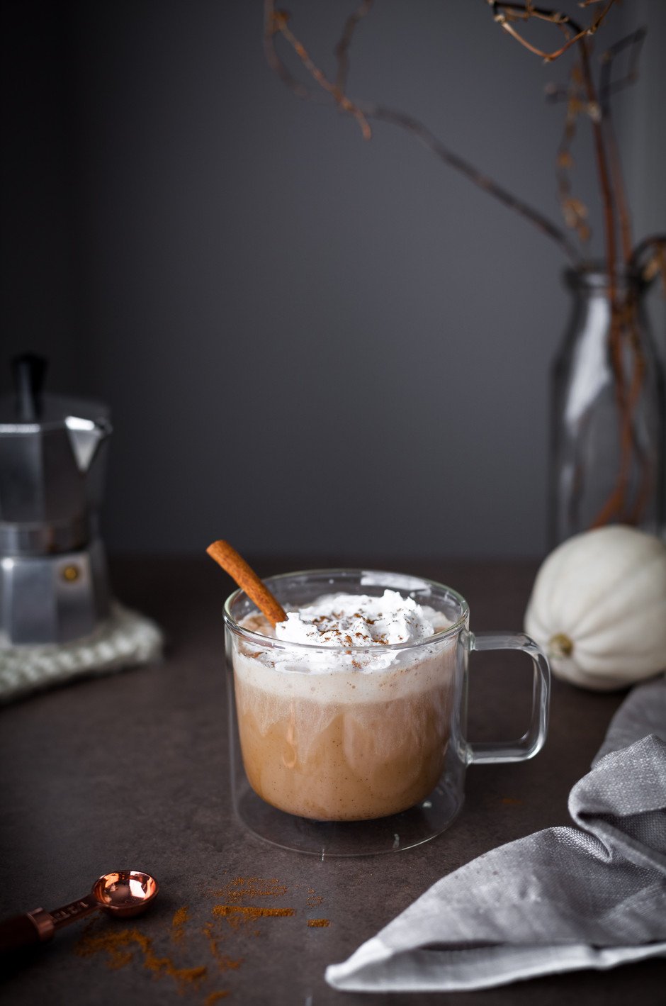 head on image of pumpkin spice latte with a pumpkin in the background.