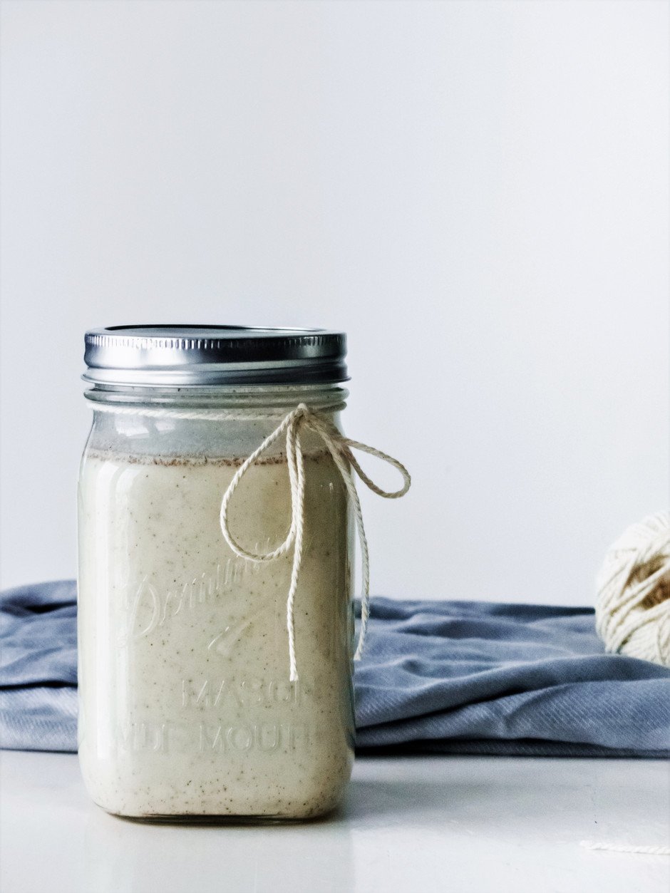 a head on image of vegan egg nog in a mason jar with a twine bow.
