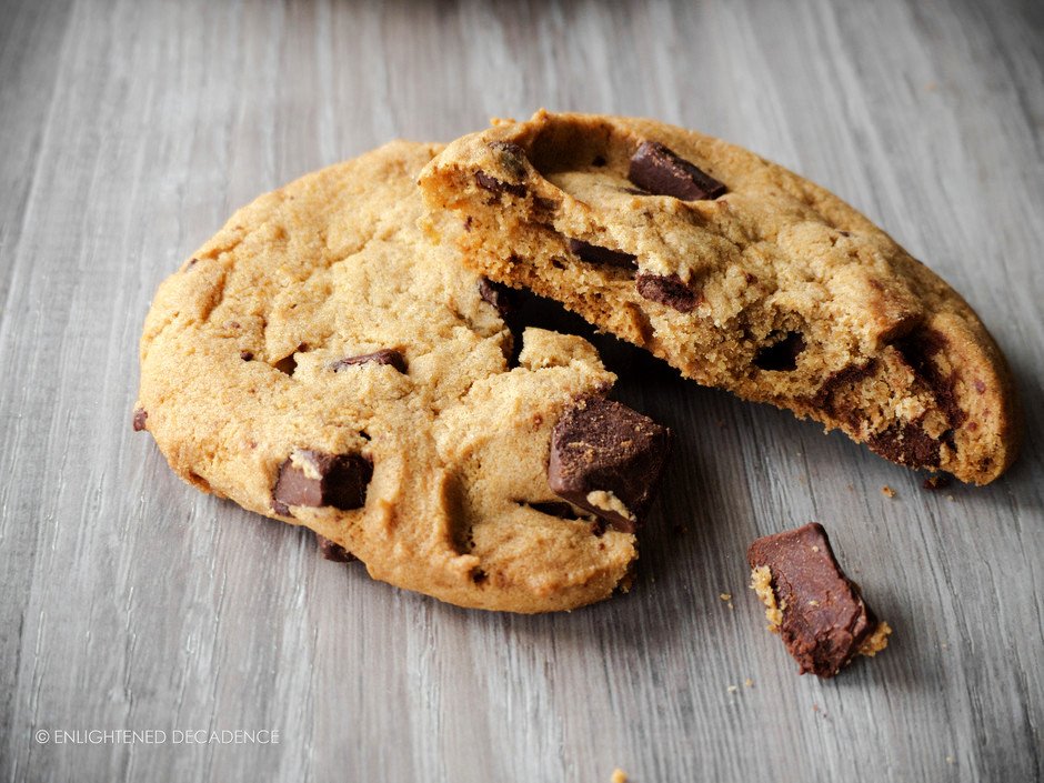 a close up of a chewy vegan chocolate chip cookie broken in half.