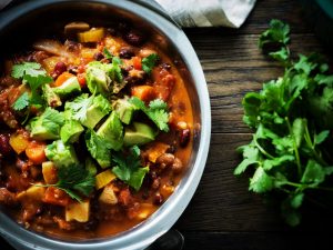 a close up overhead of sweet potato chilli with avocado and cilantro.