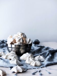 head on image of vegan meringue cookies in a stainless bowl.