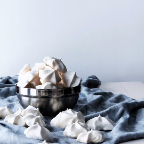 head on image of vegan meringue cookies in a stainless bowl.