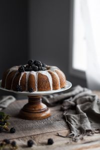 a head on image of a blackberry bundt cake sitting by window