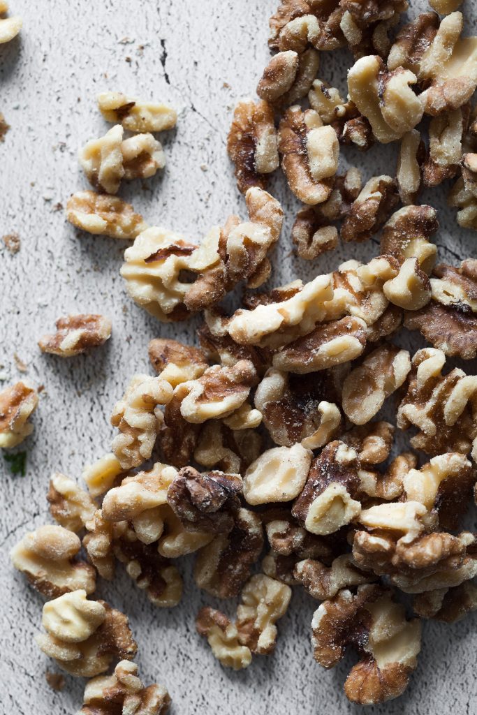 walnuts halves on a stone surface.