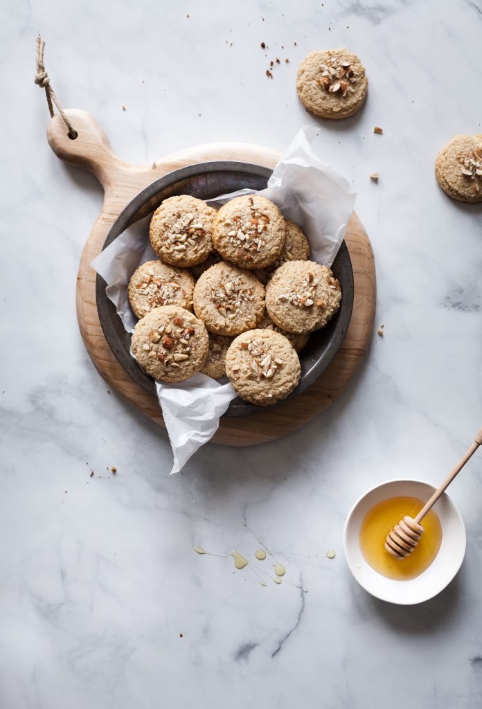 almond cookies in a tray with maple syrup on the side.