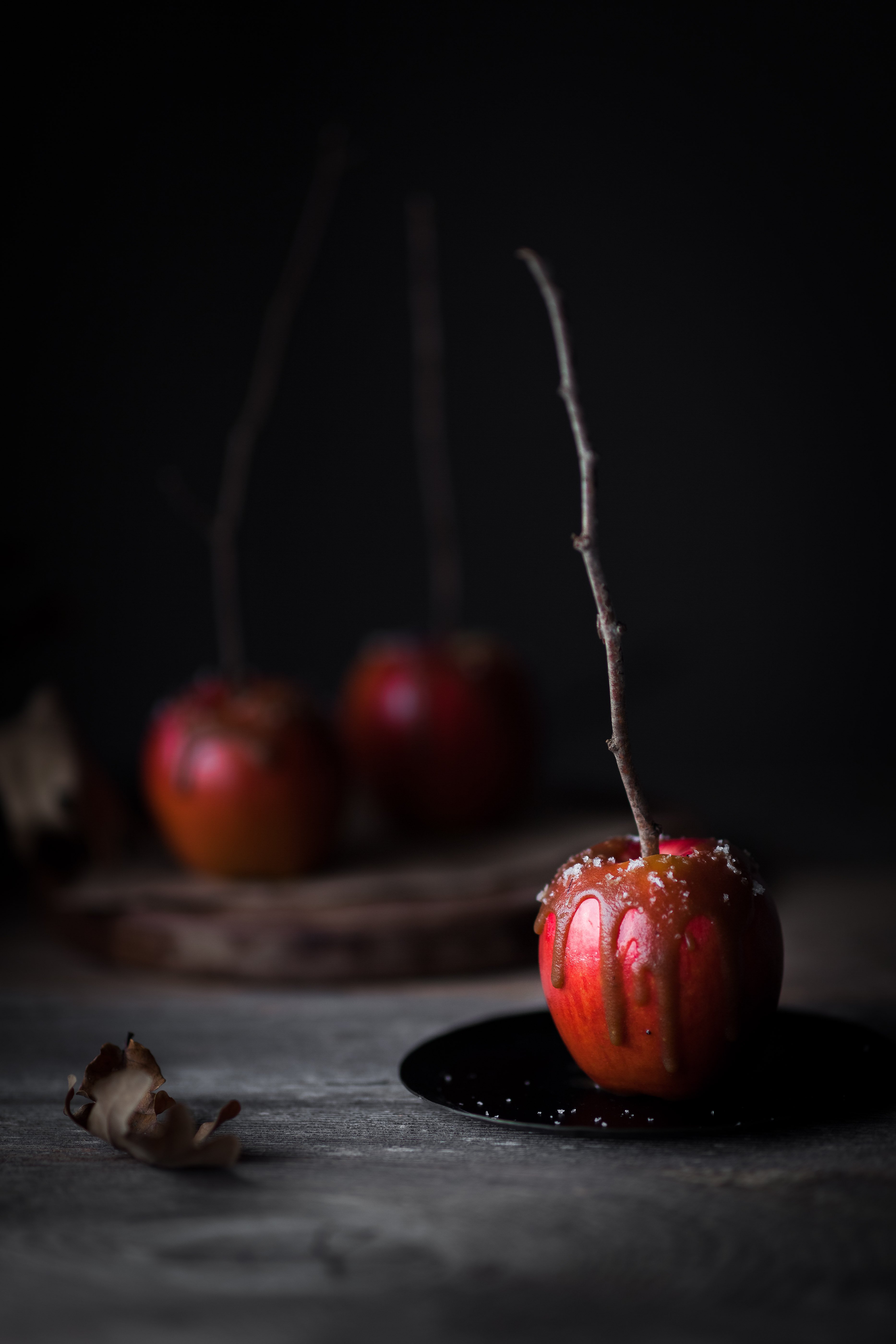 a portrait view of a salted caramel apples with two in the background.