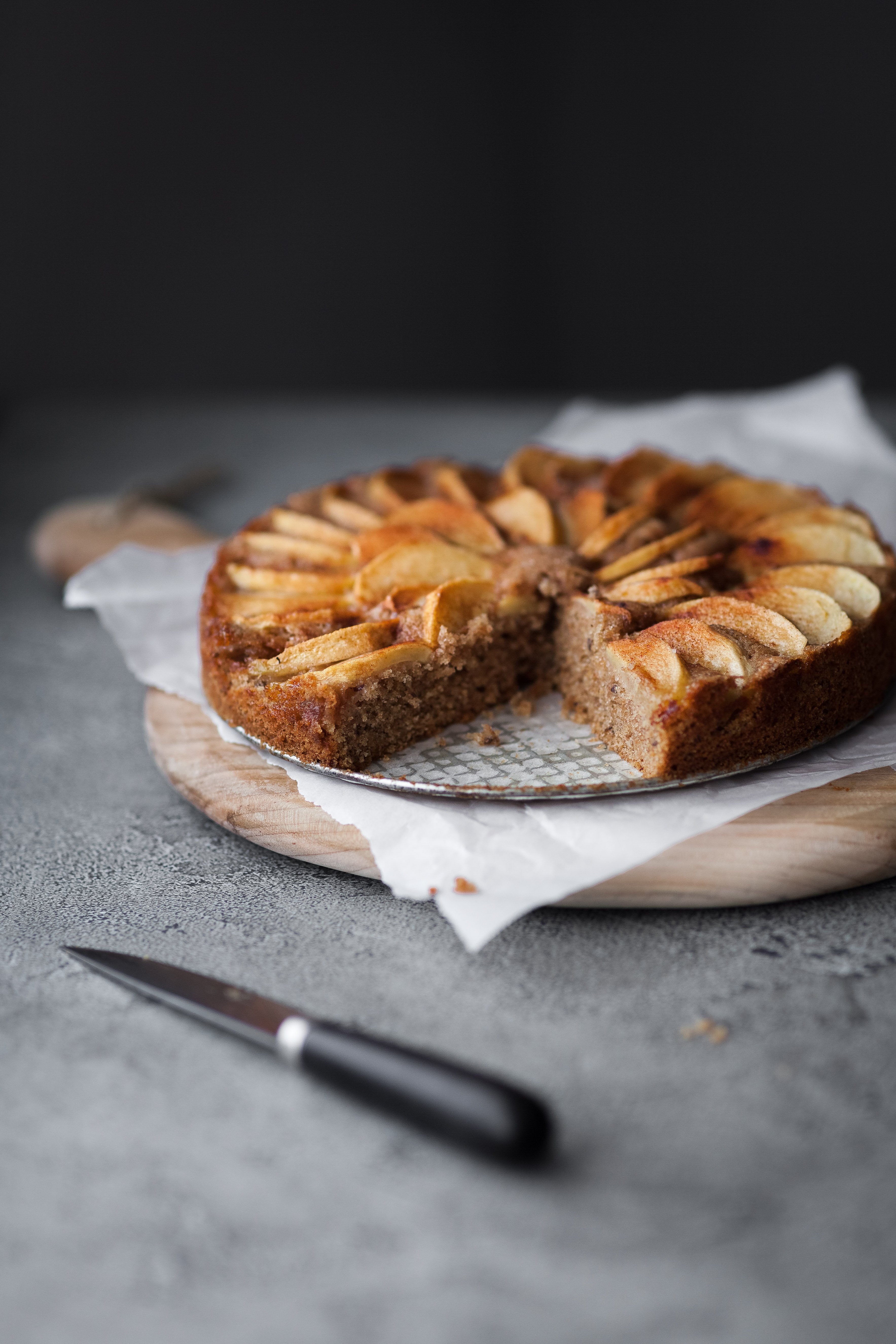an angled shot of vegan german apple cake with a slice removed.