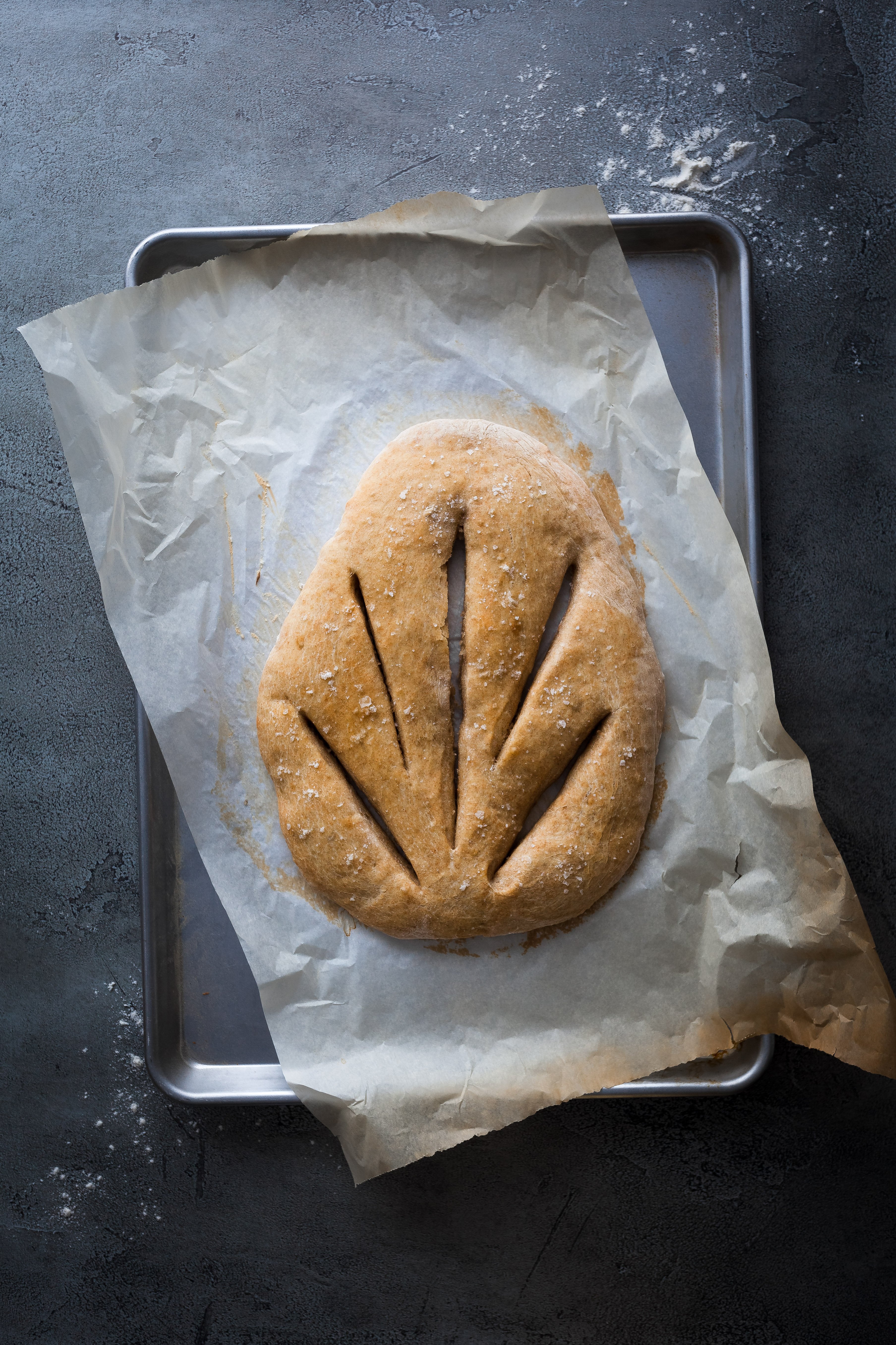 An overhead image of a No Knead Garlic Fougasse on a parchment lined baking sheet.