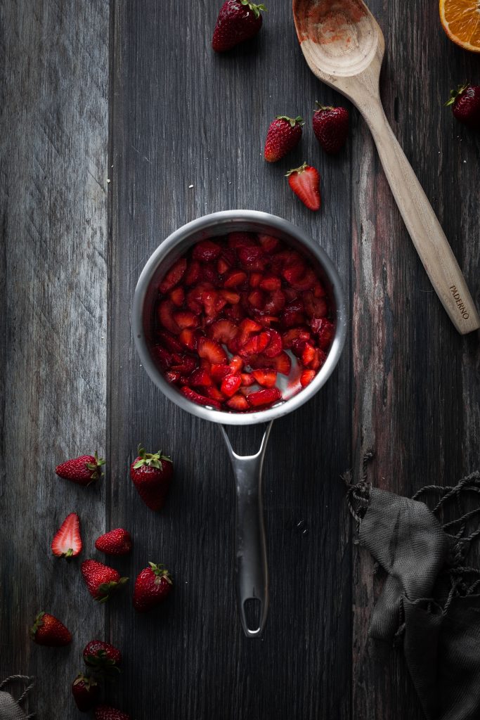 an overhead image of strawberries in a saucepan.