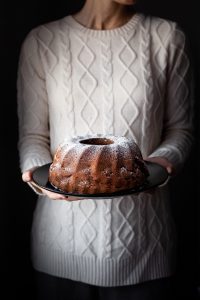 head on image of vegan apple spice cake in bakers hands.