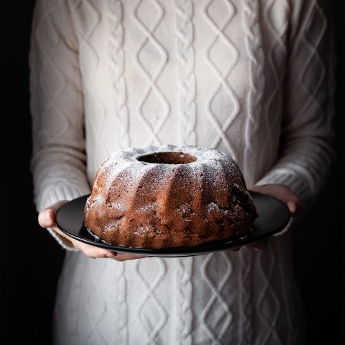 head on image of vegan apple spice cake in bakers hands.