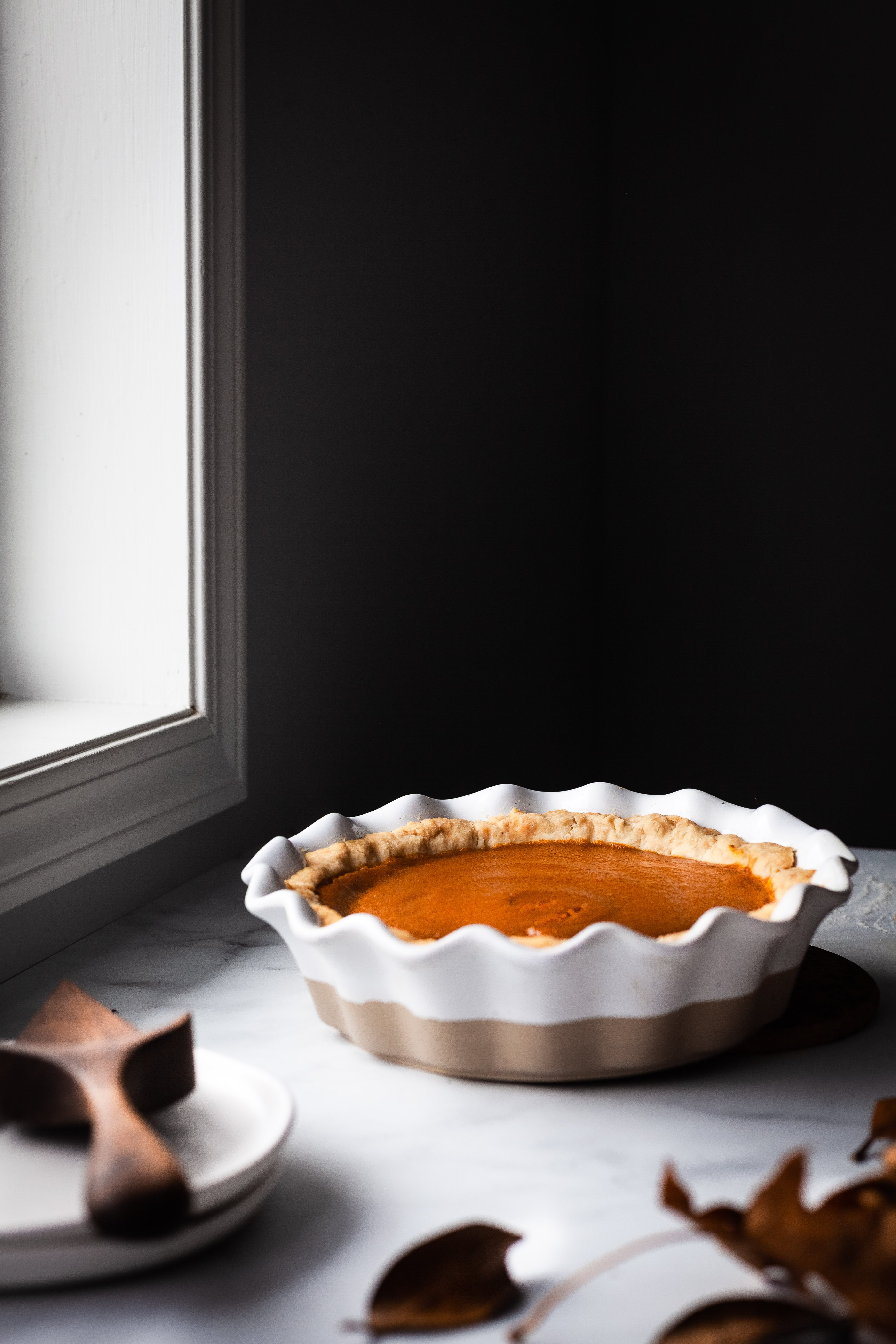 head on image of vegan pumpkin pie sitting by a window.