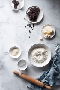 an overhead image of baking ingredients with a rolling pin and blue linen off to the side.