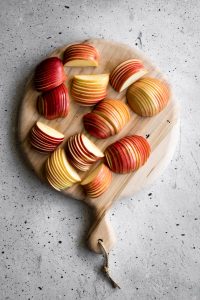 overhead image of several sliced apple section on a cutting board.