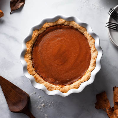Overhead view of a pumpkin pie in a ceramic baking dish.