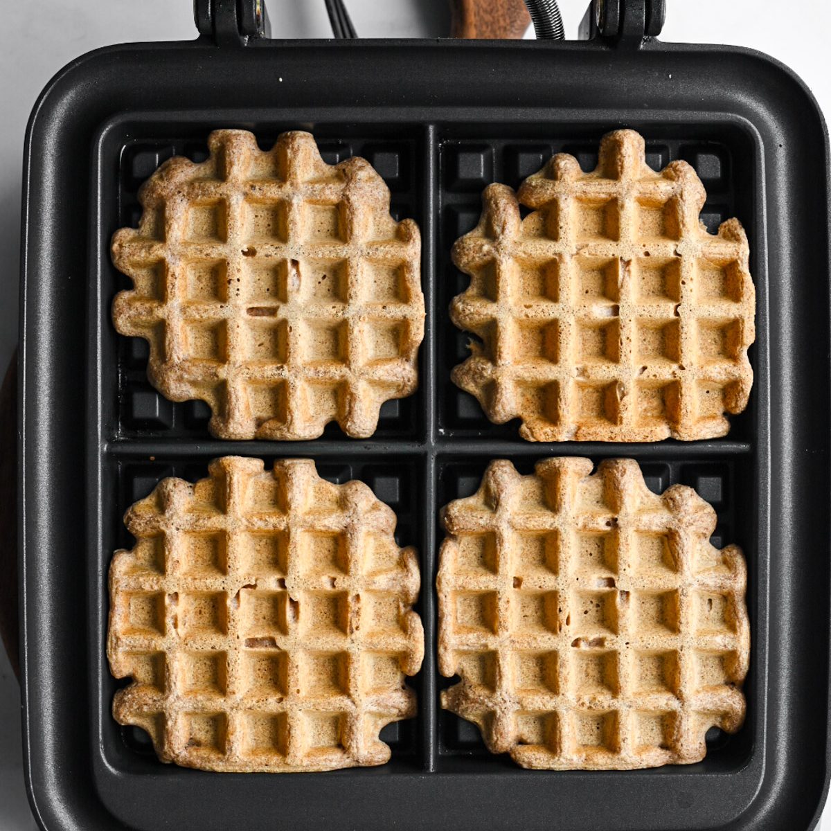Fully cooked spelt waffles in a waffle iron.