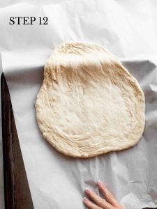 a baker sliding dough and parchment onto a baking sheet with text "step 12".