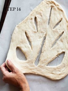 a baker tugging patterned dough into a wider shape with text overlay "step 14".