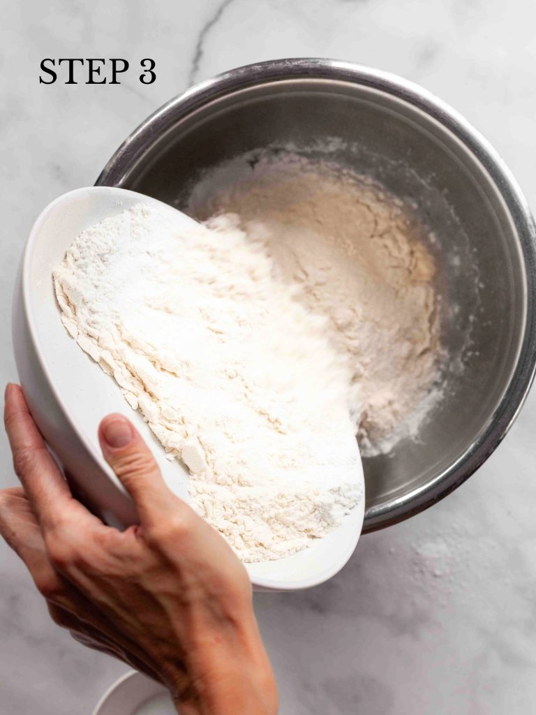 flour being poured into a stainless bowl filled with yeast and water with text overlay "step 3".