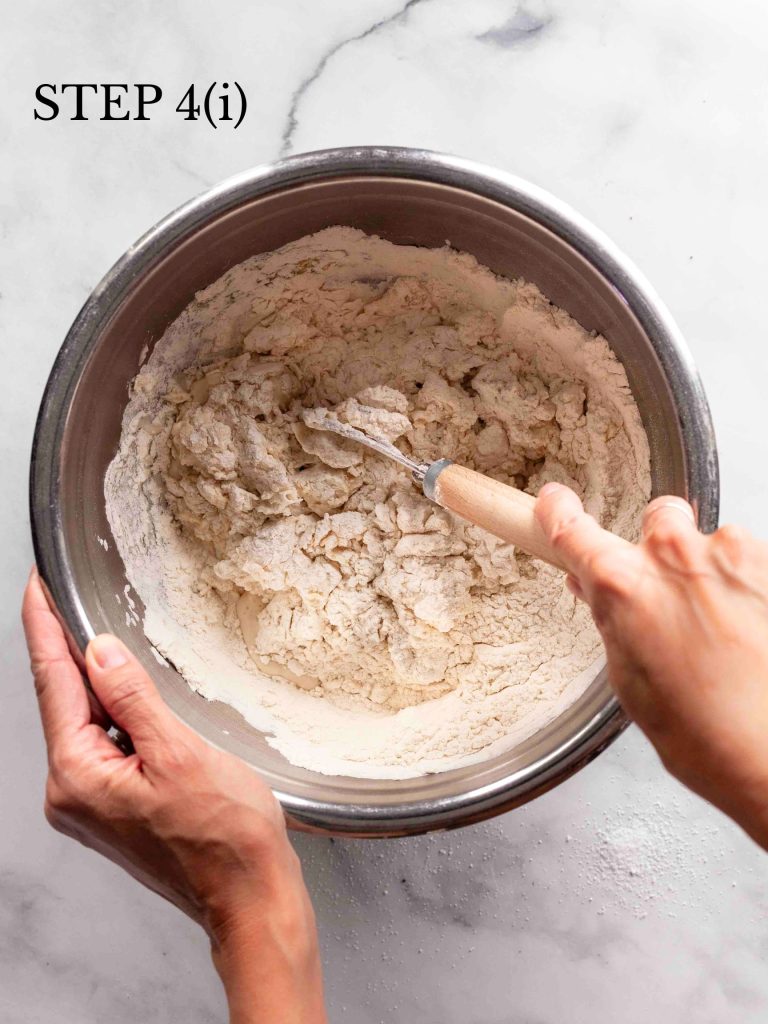 a baker stirring flour and water with a whisk with text overlay "step 4i".