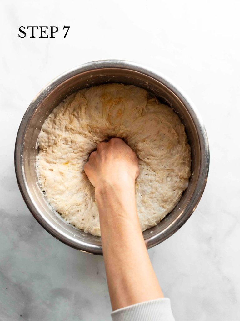 a hand deflating proofed dough with text overlay "step 7"