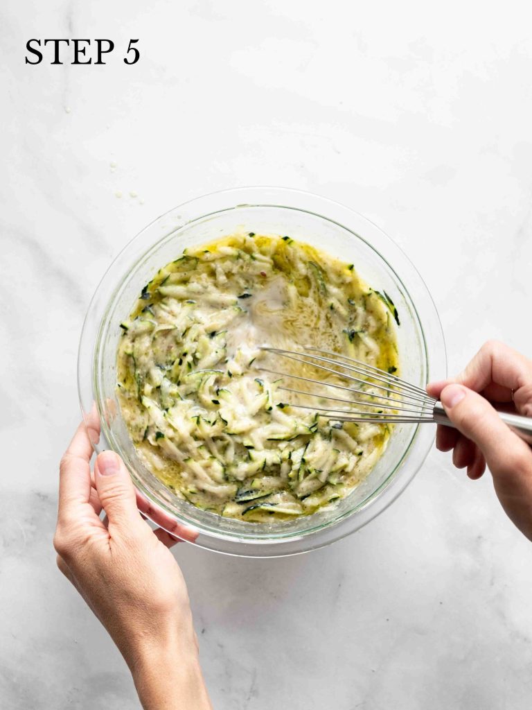 zucchini, oil, milk, vanilla and flax seed being blended with a whisk.