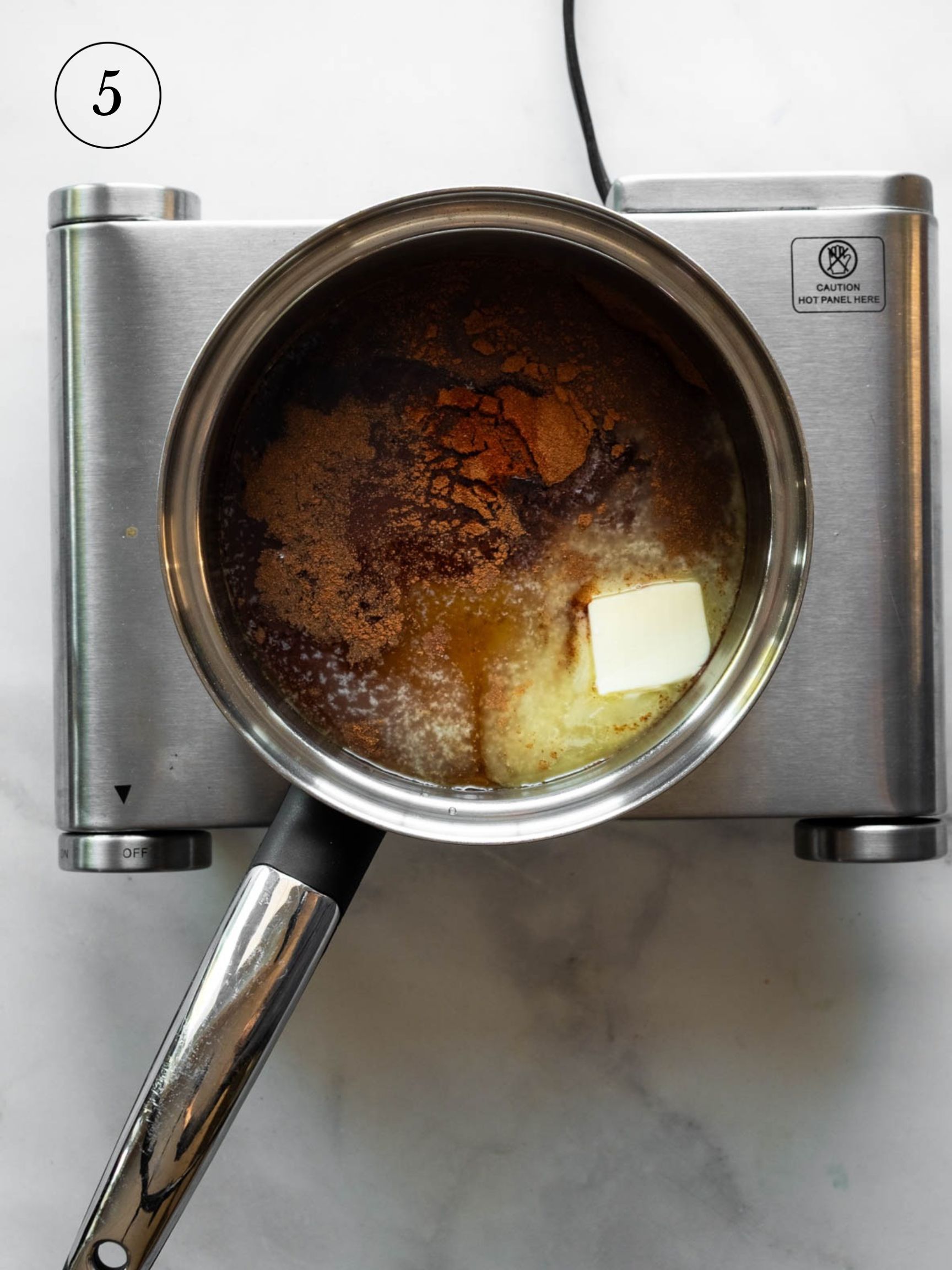 the ingredients for glaze melting in a small saucepan on a cook top.